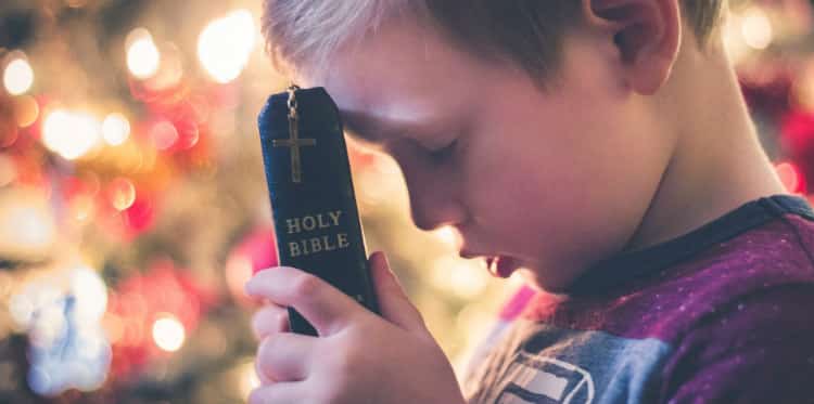 Child Praying Over Bible