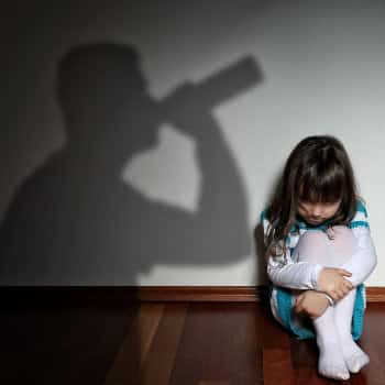 child in shadow of drinking father