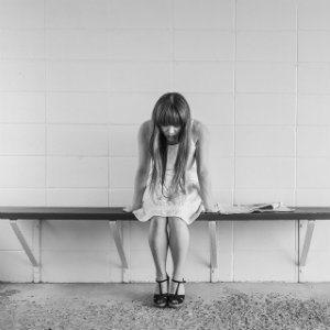 depressed girl sitting on bench
