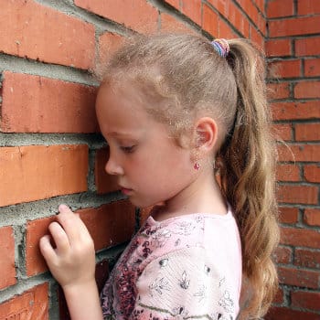 sad girl by brick wall
