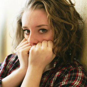 scared young woman covering mouth