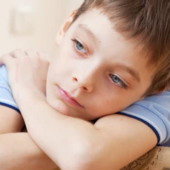 young boy with head in arms